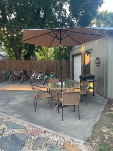 科达伦Yellow Rocker Bungalow - Feels like home!的带桌椅和遮阳伞的露台 更多25张照片