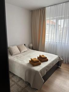 una camera da letto con un letto con due asciugamani sopra di Urban apartament a Craiova