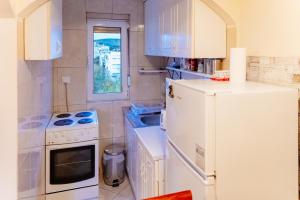 Una cocina con un refrigerador blanco y un fregadero. en Milenijum apartman, en Podgorica