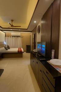 a bedroom with a bed and a desk with a computer on it at Ostro Inn Royal Studio Apartment Shakespeare Sarani in Kolkata +5 photos