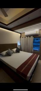 a large bed in a room with a window at Ostro Inn Royal Studio Apartment Shakespeare Sarani in Kolkata