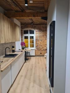 eine Küche mit Holzböden und einer Ziegelwand in der Unterkunft Piernikowy Strumyk in Toruń