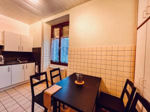 a kitchen with a table and chairs in a room at La Vallée d Anna in Munster
