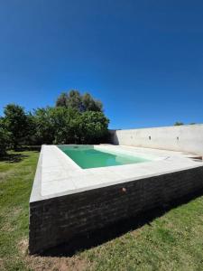 a swimming pool in the grass next to the ocean at Las Golondrinas in Santa Rosa