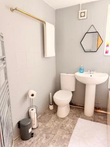 ein Badezimmer mit einer weißen Toilette und einem Waschbecken in der Unterkunft A cozy, comfortable, calm house perfect for groups in Swansea + 10 Fotos