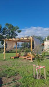 einen Pavillon mit einem Tisch und Stühlen auf einem Feld in der Unterkunft Complejo Brisas De Las Sierras in Villa Ciudad Parque