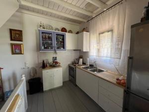 a kitchen with white cabinets and a sink and a window at House of Thaleia in Manolátes
