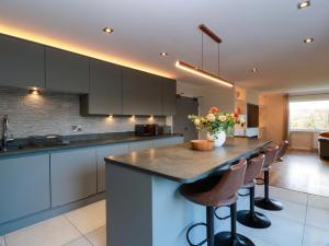 a kitchen with a large island with bar stools at Cramar Cottage in Glasgow