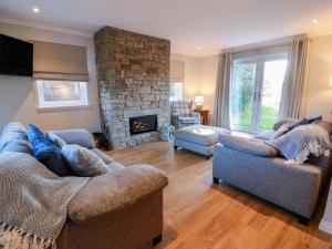 a living room with two couches and a stone fireplace at Cramar Cottage in Glasgow