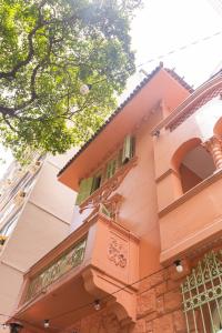 un edificio rosa con balcone e albero di Che Lagarto Hostel Copacabana a Rio de Janeiro