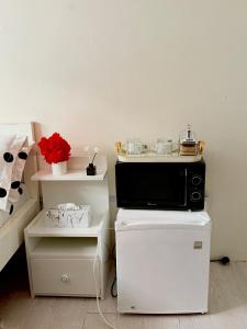Un horno microondas colocado encima de un refrigerador. en The Hideout-Studio Apartment in Westlands, en Nairobi