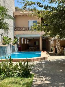 a house with a swimming pool in front of a house at Bungalows villas belen in Cedro