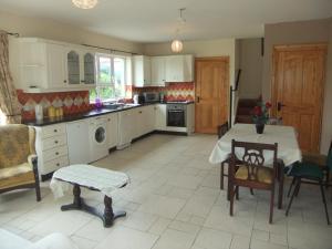 eine Küche mit einem Tisch und Stühlen sowie ein Esszimmer in der Unterkunft Daleview Apartment in Manorcunningham