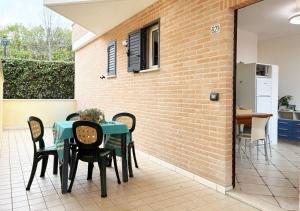 a patio with a table and chairs and a brick wall at Holihome Vascello B21 in Tortoreto Lido