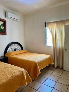 a bedroom with two beds and a window at Bungalows villas belen in Cedro