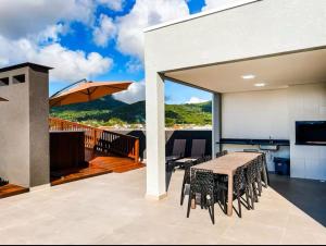 een terras met een tafel en stoelen op een balkon bij Bela Vista in Matinhos