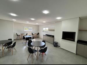 a room with tables and chairs and a flat screen tv at Bela Vista in Matinhos