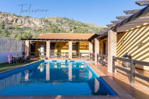 a swimming pool in front of a house at Todimer villa refugio in Vélez de Benaudalla