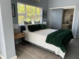 a bedroom with a large bed and a window at Rissie's Villa in Gordonʼs Bay