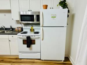 a kitchen with a white refrigerator and a microwave at Jungle House Luxury Homes - Columbus Downtown Short North - Steps to Convention Center & Nationwide Arena - Sleeps up to 8 - Free Parking - Over 5,800 Five Stars in Columbus +18 photos