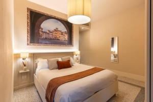 Un dormitorio con una cama con un cuadro en la pared. en Noble Floor - Private Sauna Apartment, en Lucca