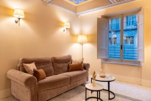 Una sala de estar con un sofá y una ventana. en Noble Floor - Private Sauna Apartment, en Lucca