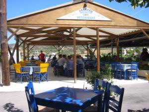 a restaurant with tables and chairs under a pavilion at Hotel Palazzo in Archangelos