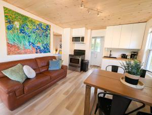 un soggiorno con un divano marrone e un tavolo di Les Refuges des Monts a Saint-Tite-des-Caps