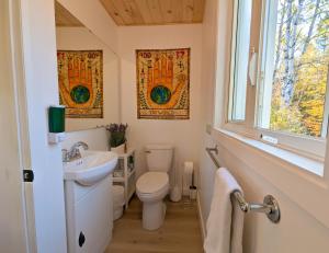 un bagno con un water, un lavandino e una finestra di Les Refuges des Monts a Saint-Tite-des-Caps Altre 185 foto