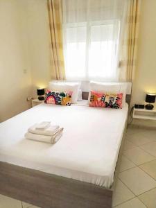 Reta-Inn Martil Beach في مرتيل: سرير ابيض كبير عليه منشفتين