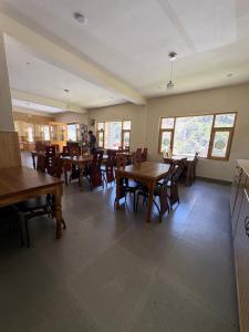 a dining room with wooden tables and chairs at Sun Beam Hotel Koksar in Khoksar