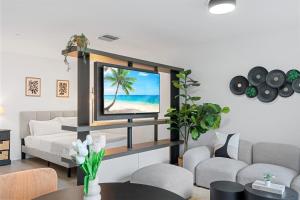 a living room with a tv with a picture of a beach at High-Rise Luxury Condo in Downtown Miami in Miami