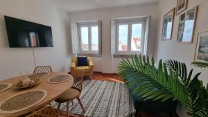 een woonkamer met een tafel en een plant bij Fonte do Norte in Ericeira