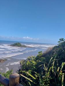 a view of a beach with the ocean at Apartamento na praia 2 qt com quintal e churrasqueira in Itanhaém