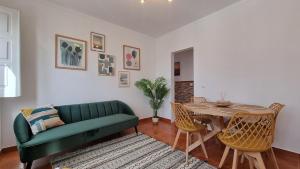 een woonkamer met een groene bank en een tafel bij Fonte do Norte in Ericeira