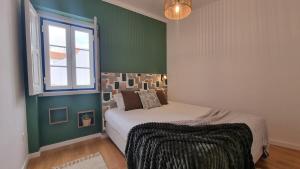 een slaapkamer met een bed en een raam bij Fonte do Norte in Ericeira