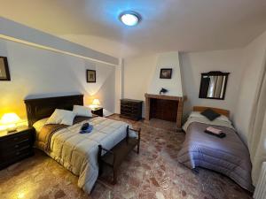 una camera da letto con due letti e un camino di Casa Rural El Olivo a Alatoz