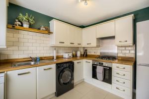 a kitchen with white cabinets and a dishwasher at NEW! Private Driveway, Spacious, 2 Bathroom, Fast WiFi in Berkswell