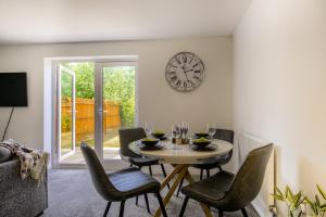 a dining room with a table and chairs and a clock at NEW! Private Driveway, Spacious, 2 Bathroom, Fast WiFi in Berkswell +16 photos