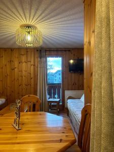 a room with a wooden table and a chandelier at Samoëns à Pied – Appt 4 pers in Samoëns
