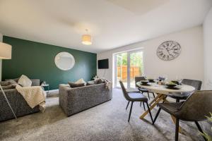 a living room with a table and a clock on the wall at NEW! Private Driveway, Spacious, 2 Bathroom, Fast WiFi in Berkswell