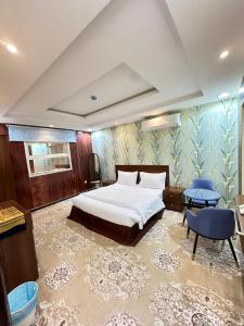 a bedroom with a bed and two blue chairs at تاج 2 in Al Kharj