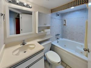 a bathroom with a sink and a toilet and a tub at Harbour Beach Resort 203 in Seabreeze +27 photos