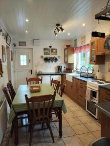 una cocina con mesa y sillas. en Carnowen Cottage, en Ringsend