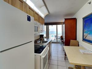 a kitchen with a sink and a counter with a table at Harbour Beach Resort 203 in Seabreeze