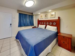 a bedroom with a blue bed with a wooden headboard at Harbour Beach Resort 203 in Seabreeze