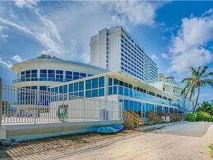 Un gran edificio con ventanas azules en una playa. en Castle Beach Club Apartments, en Miami Beach