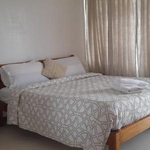 a bed with a white comforter in a bedroom at Arara Group Hotel Majuli in Majuli +4 photos