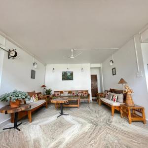 a large living room with couches and tables at Arara Group Hotel Majuli in Majuli