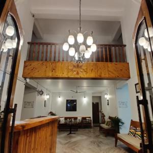 a large living room with a large chandelier at Arara Group Hotel Majuli in Majuli